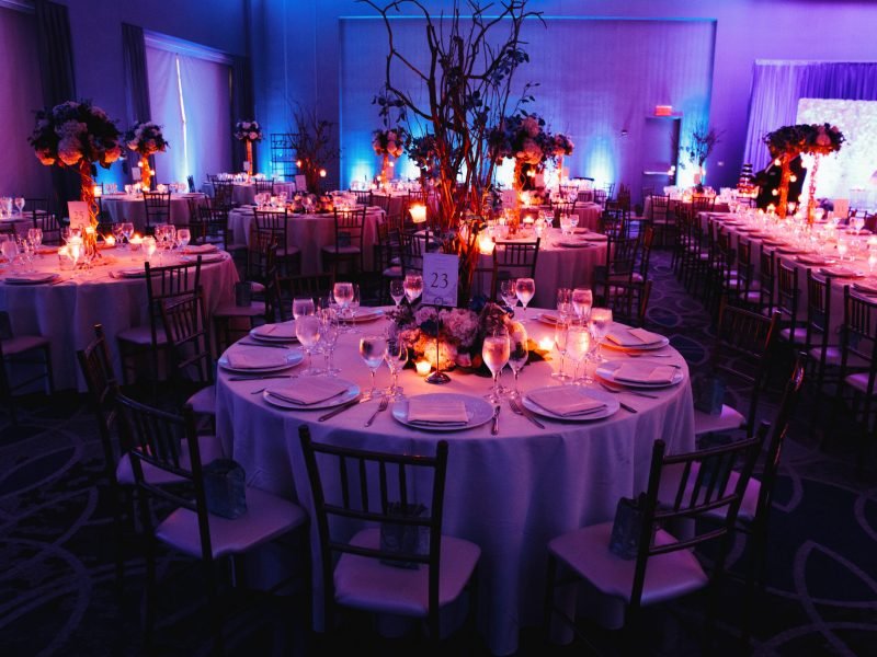 Decorated wedding hall with candles, round tables and centerpieces
