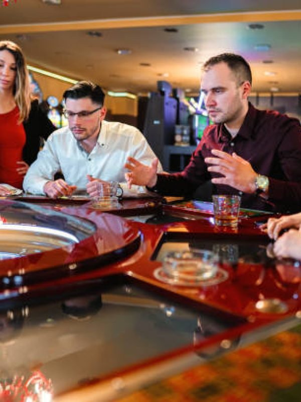 Worried group of friends playing roulette in casino